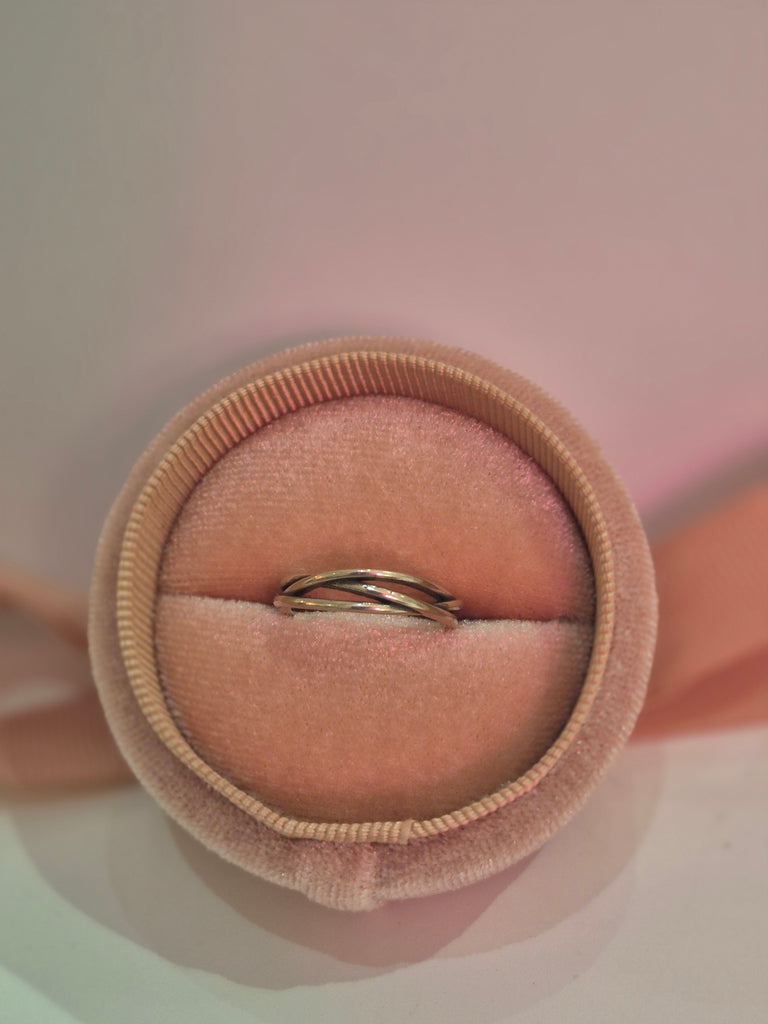 Silver twist band ring displayed in a blush velvet ring box.
