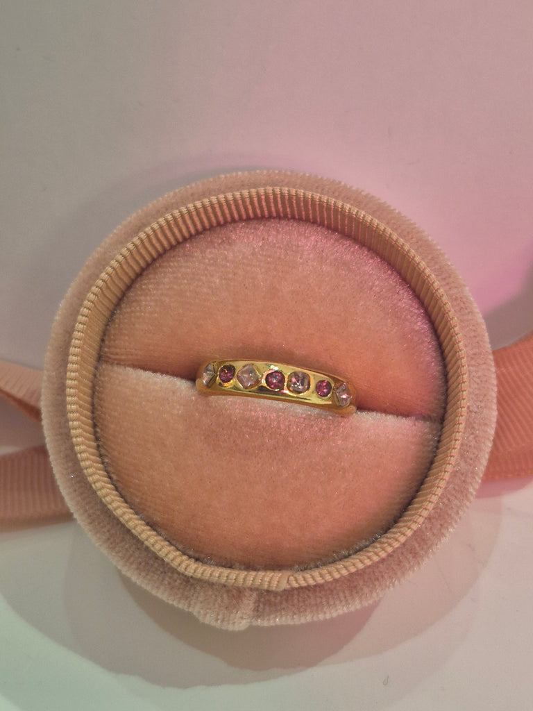 Gold ring with ruby and pink crystals displayed in a blush velvet ring box.