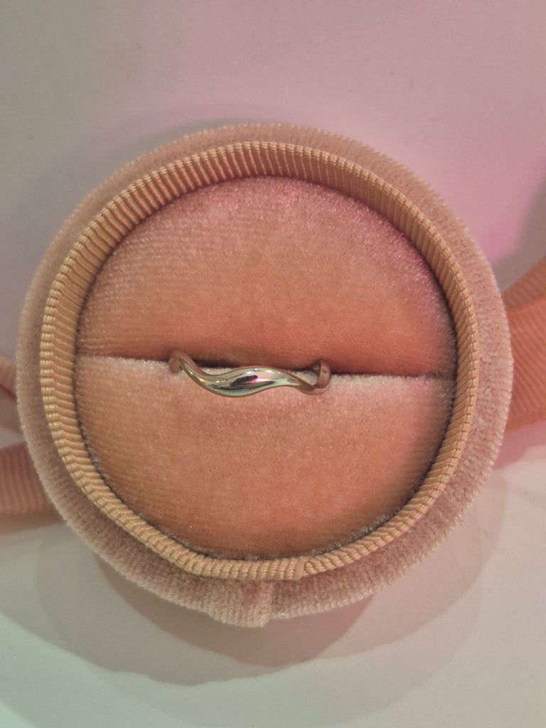 Sterling silver wave band ring displayed in a blush velvet ring box.