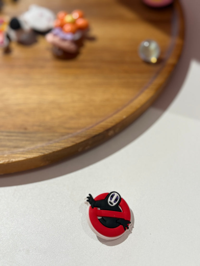 No-Face anime character inside red Ghostbusters-style logo Croc charm.