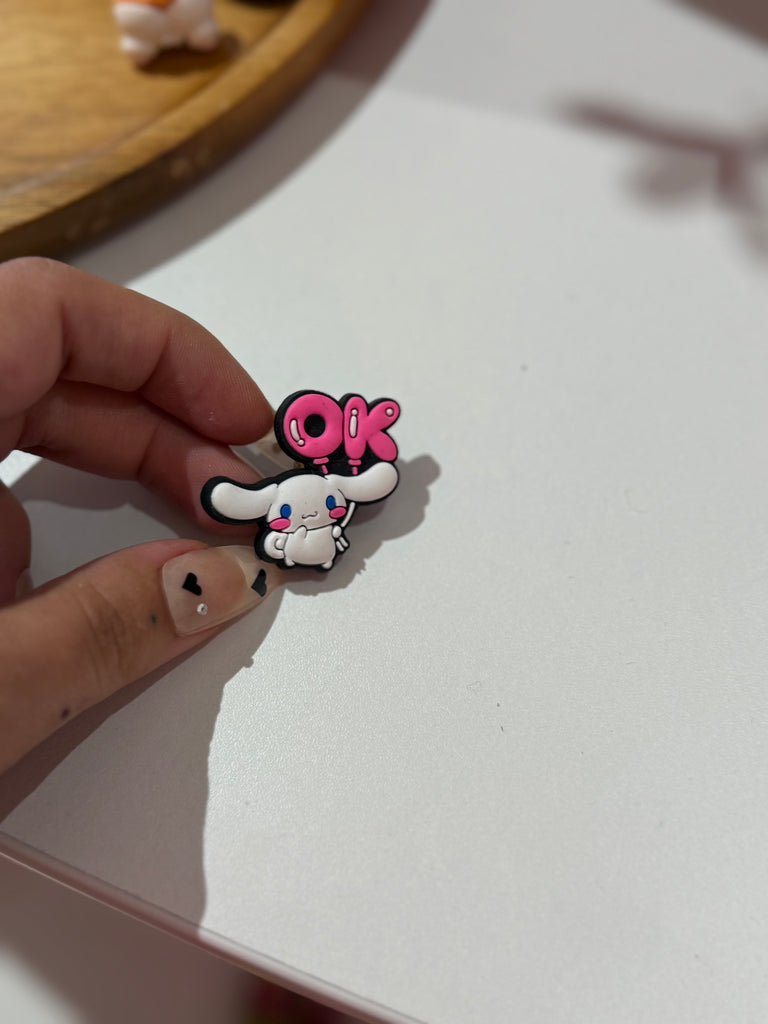Bunny holding pink “OK” Croc charm.