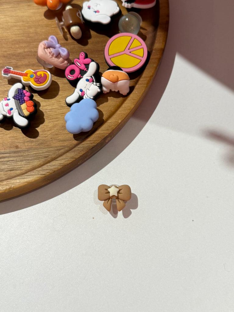 Brown bow Croc charm with cream star in the centre.