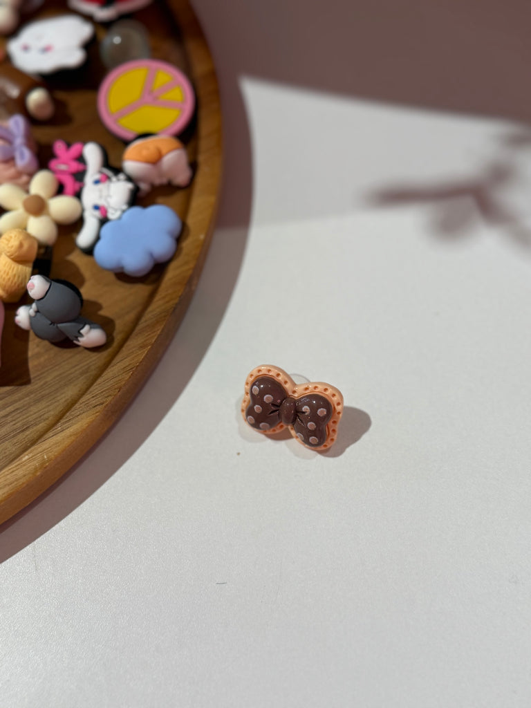 Brown polka dot bow Croc charm with white dots.