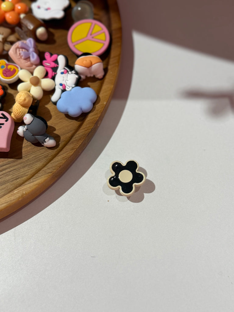 Black flower Croc charm with cream centre.