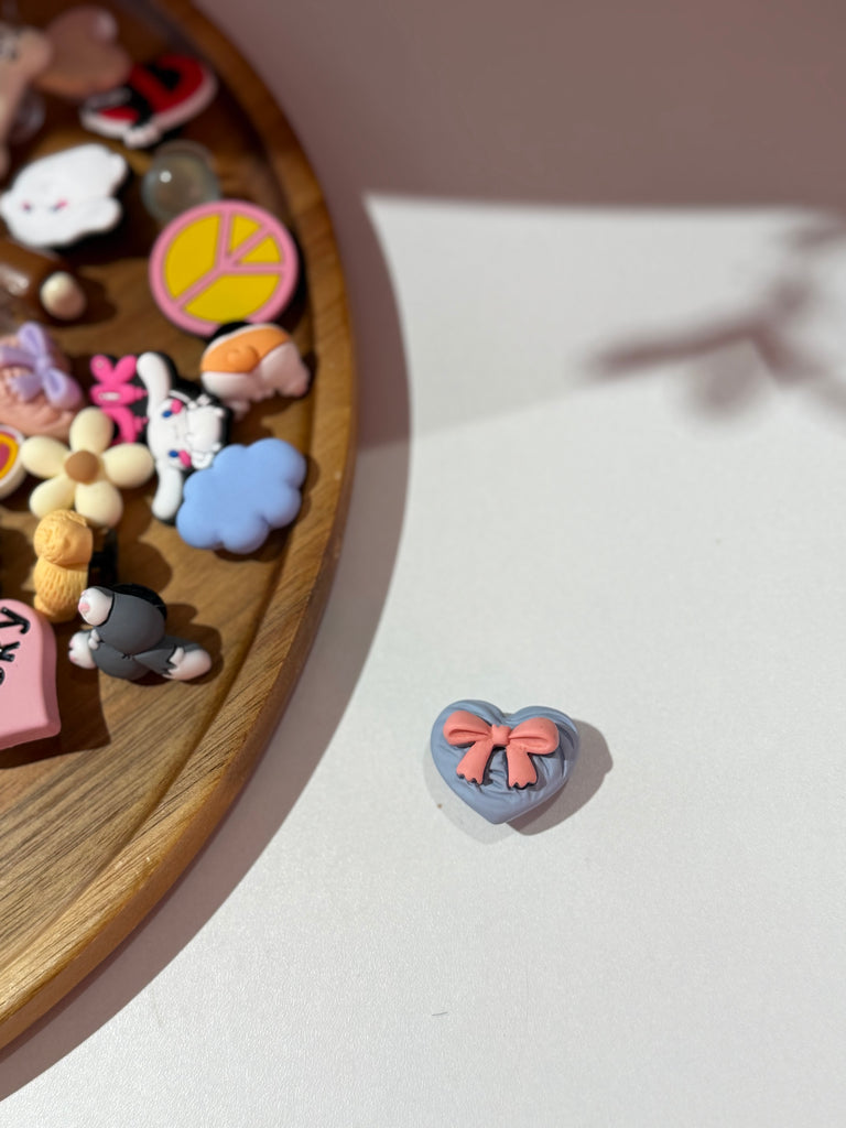 Lilac heart Croc charm with a pink bow.