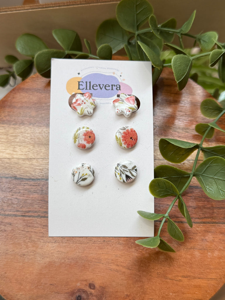 Set of three floral print stud earrings in different botanical designs.