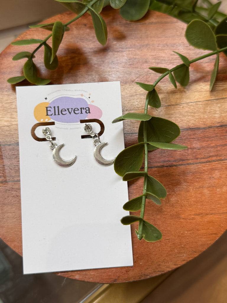 Silver crescent moon earrings with crystal stud detail.