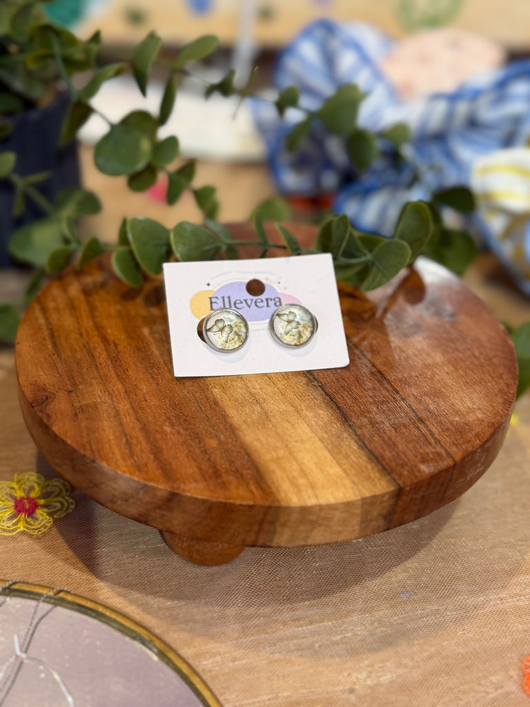 Round stud earrings with delicate gold butterfly design inside a silver frame.