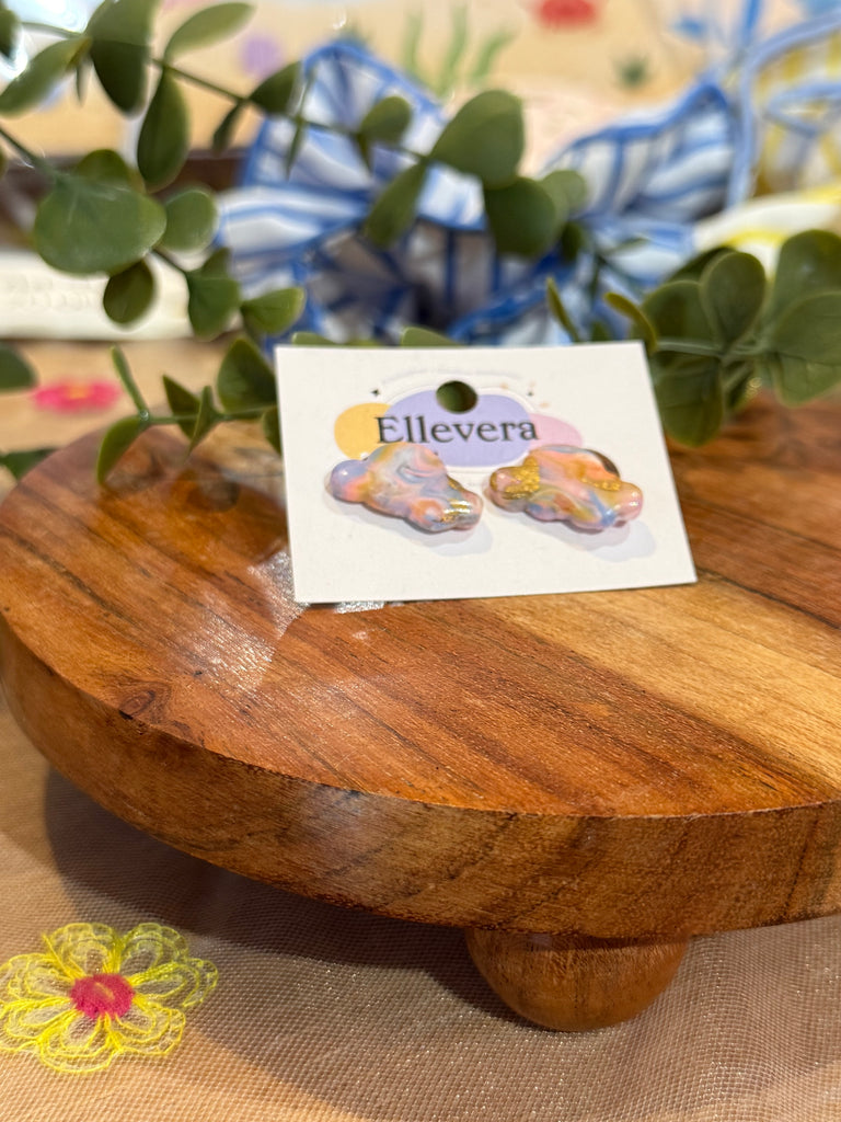 Pastel rainbow cloud-shaped stud earrings with gold glitter detail on Ellevera card.