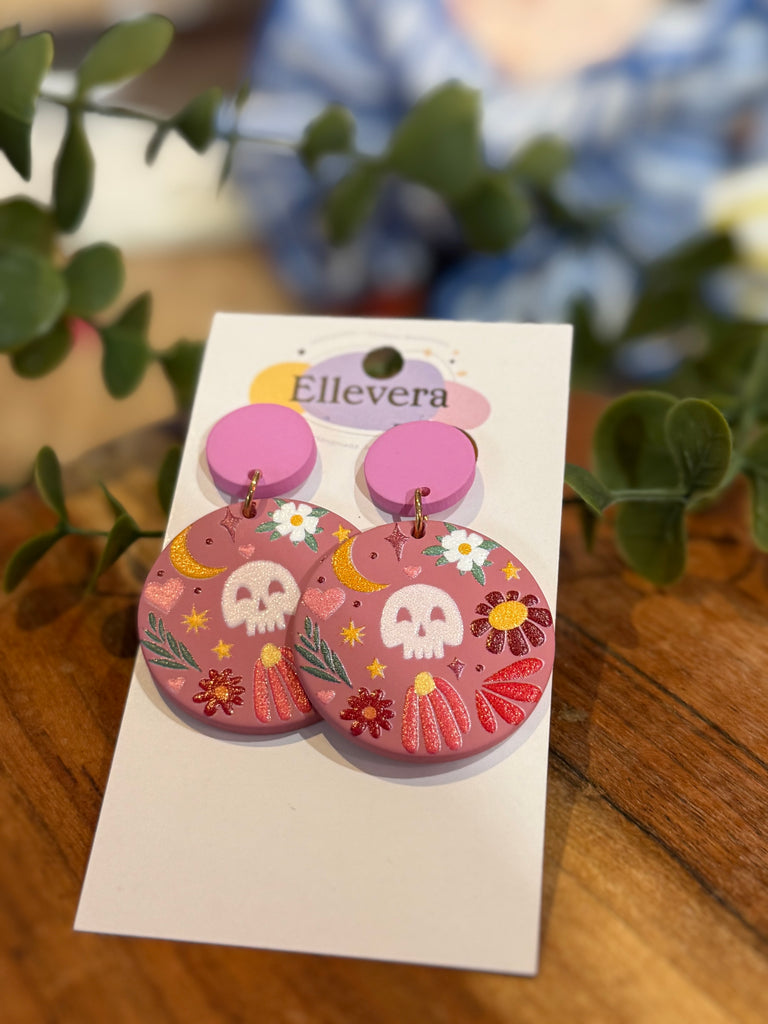 Round pink acrylic earrings with skull, moon and floral designs, Ellevera jewellery.