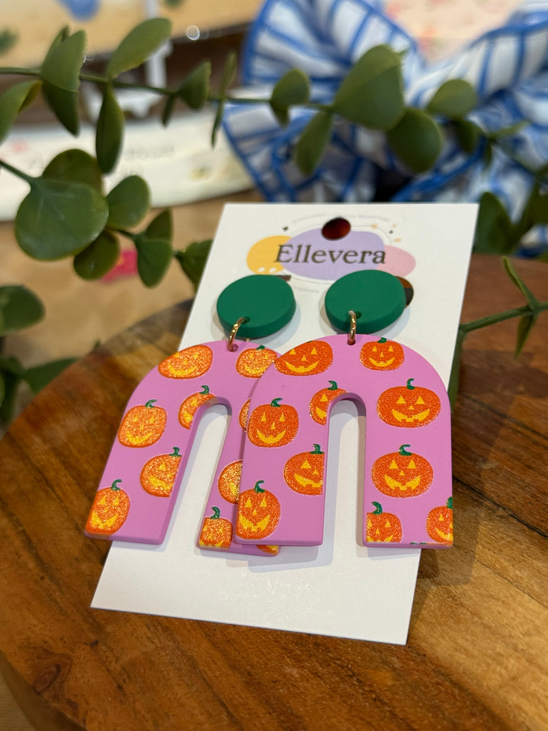 Pink arch earrings decorated with orange pumpkins, acrylic Halloween jewellery.