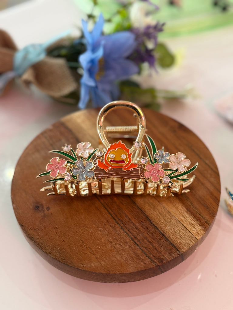 Gold floral hair claw clip featuring Calcifer from Howl’s Moving Castle surrounded by pastel enamel flowers.