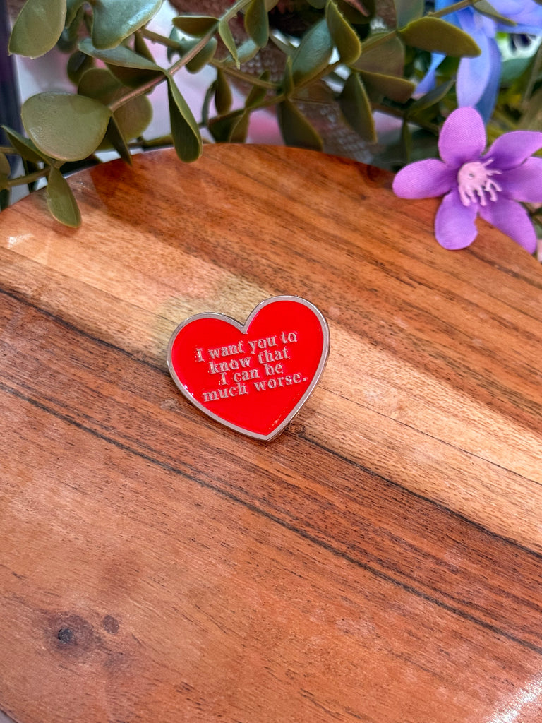 Enamel pin with red heart and white text “I want you to know that I can be much worse.”