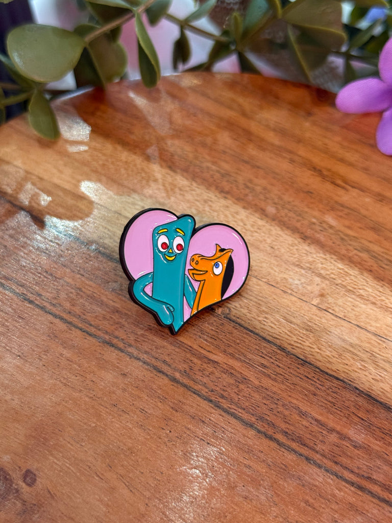 Enamel pin with two cartoon characters inside a pink heart