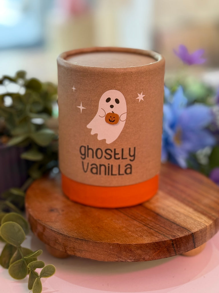 Ghostly Vanilla candle in kraft tube packaging with illustrated ghost holding a pumpkin.