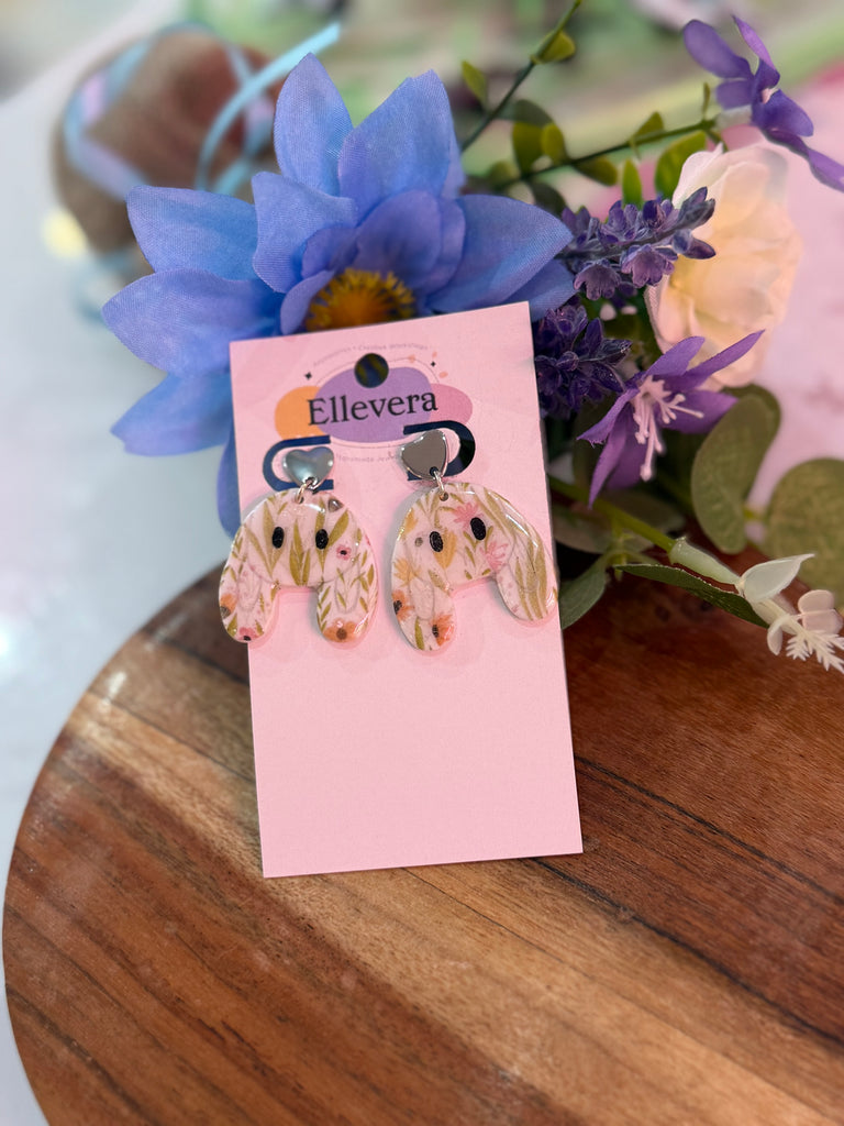 Handmade floral polymer clay bunny-shaped earrings with pastel flower design on Ellevera backing card.