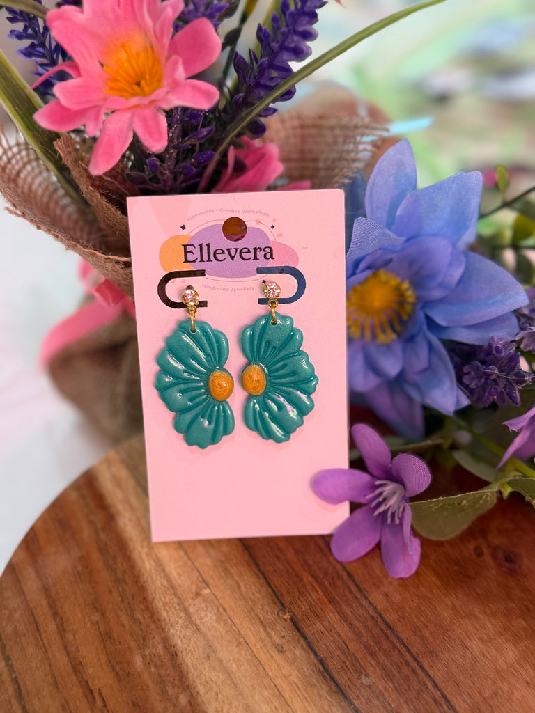 Handmade teal polymer clay earrings shaped like large flowers with golden centres.
