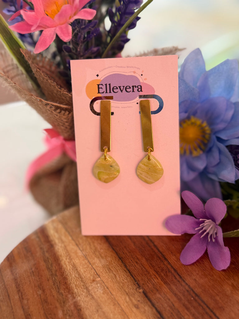 Handmade gold bar earrings with marbled yellow polymer clay drops on Ellevera backing card.