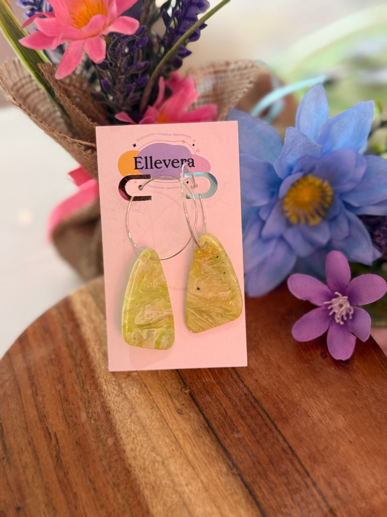 Handmade lemon swirl polymer clay drop earrings on silver hoops displayed on Ellevera backing card.