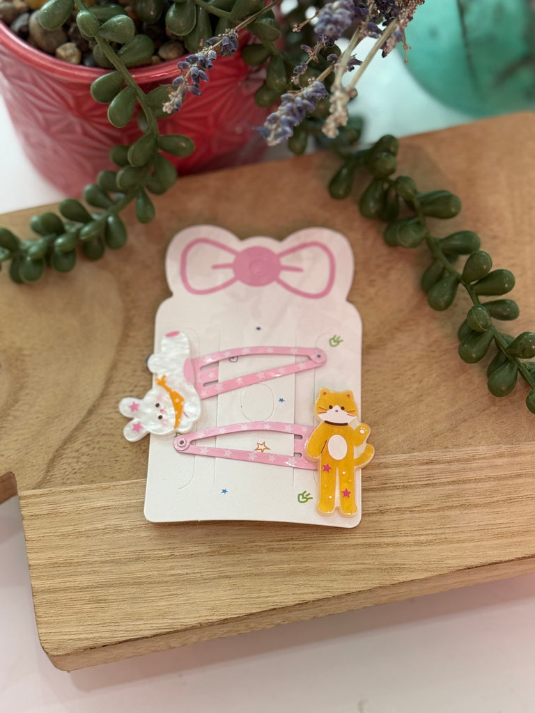 Pink hair clip set with bunny and cat design on display card.