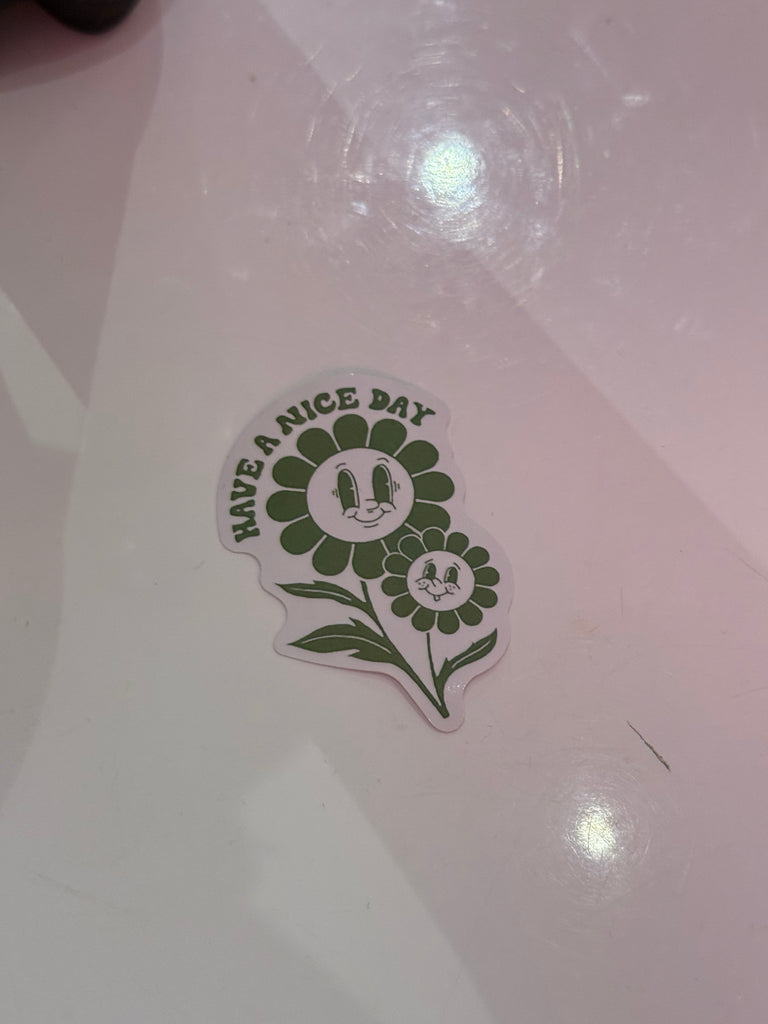 Have A Nice Day sticker with smiling green flowers in retro style.
