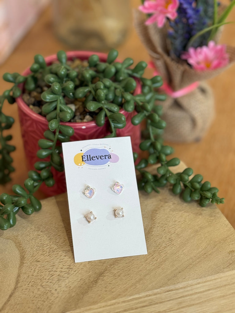 Two-pair stud earring set – pink winged heart studs and pearl studs on Ellevera card.