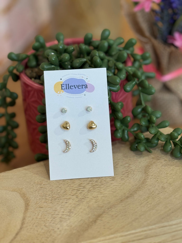 Three-pair stud earring set – crystal gem studs, puffed gold heart studs, and crystal moon studs on Ellevera card.