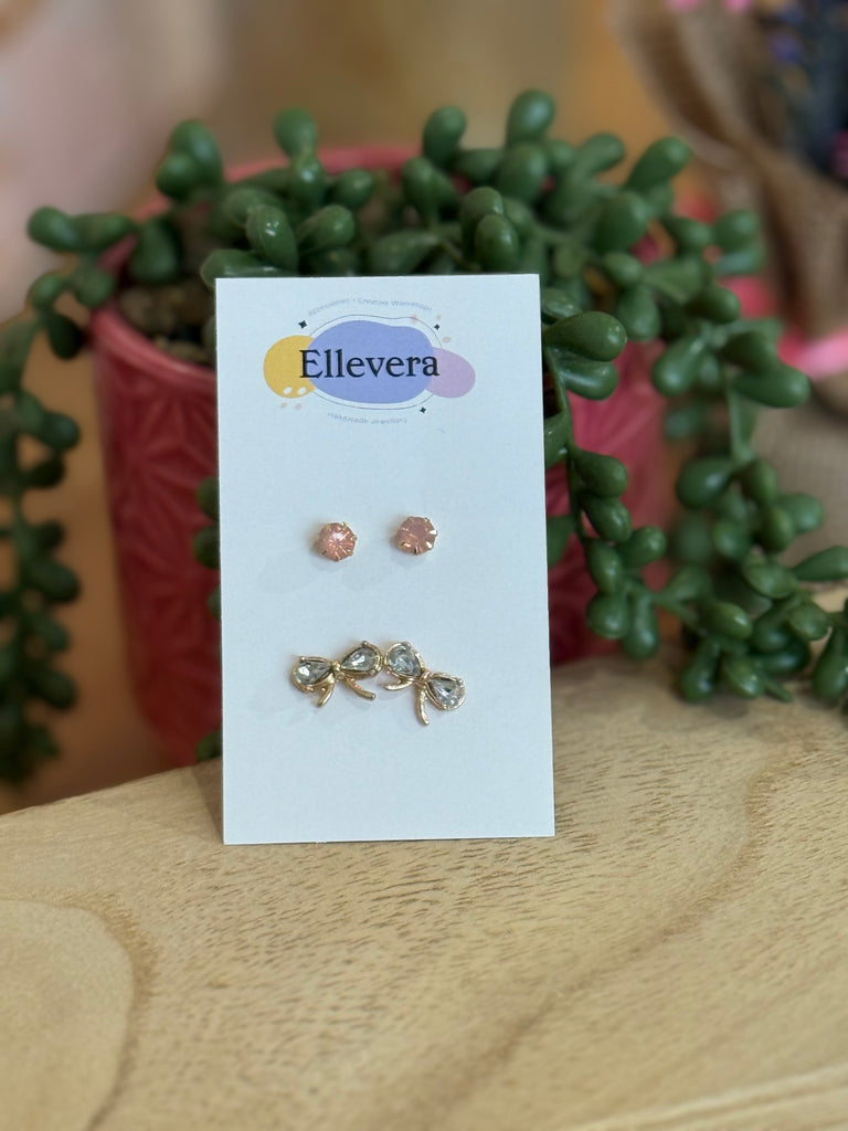 Two-pair stud earring set – pink gemstone studs and gold-tone crystal bow studs on Ellevera card.