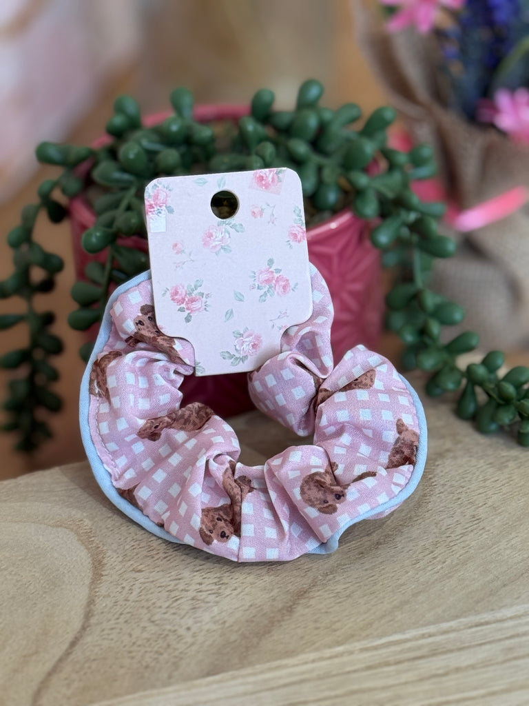 Pink gingham scrunchie with teddy bear print on floral backing card.