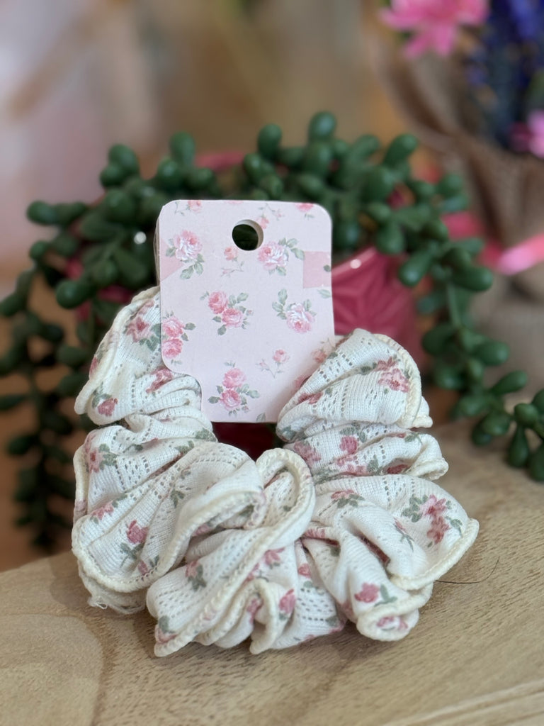 Cream scrunchie with pink floral pattern displayed on a floral backing card.