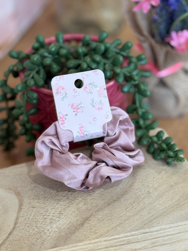 Blush pink satin scrunchie displayed on floral backing card.
