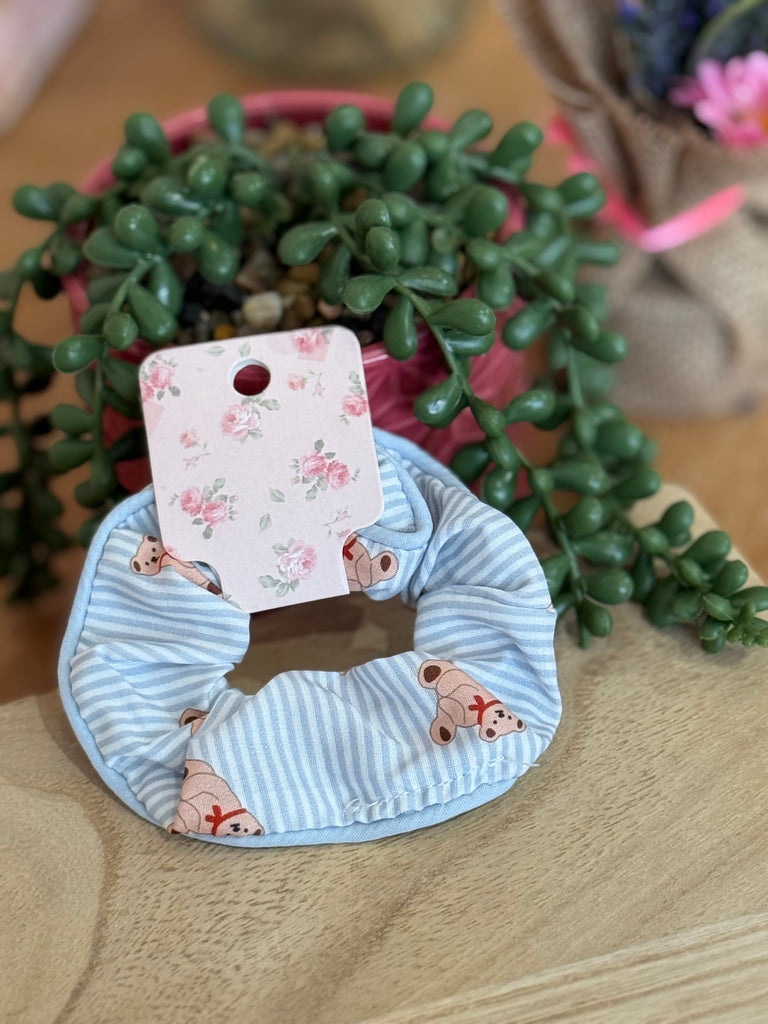 Blue striped scrunchie with teddy bear print on floral backing card.