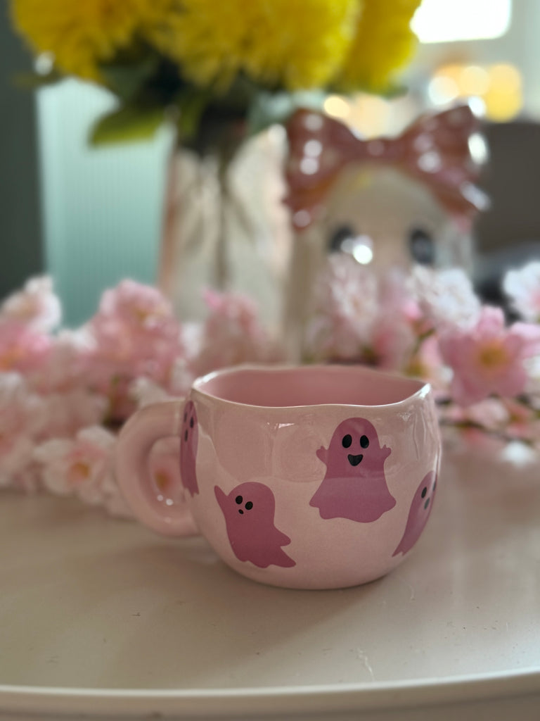 Pink ceramic mug with cute pink ghost illustrations surrounded by pink flowers
